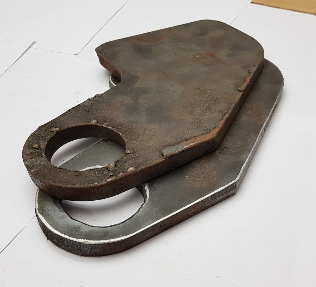 As-cut plate with heavy slag and scale on top of a processed plate