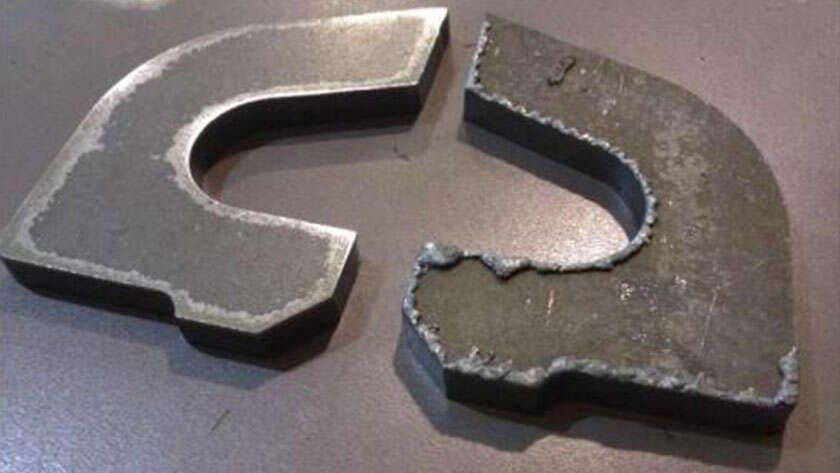 Thermal-cut steel part after slag removal, left, beside an as-cut part with heavy slag, right
